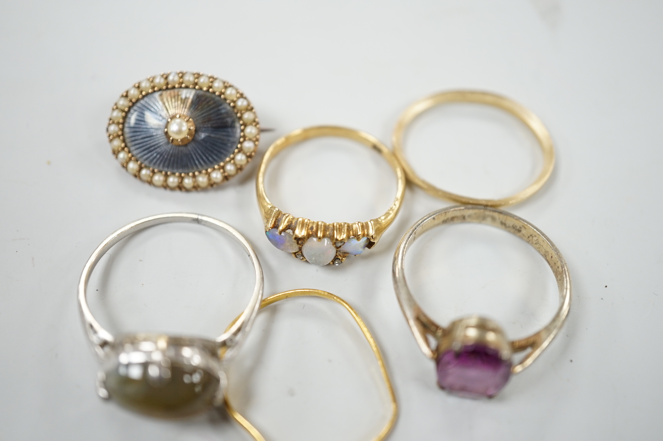 An early 20th century 18ct and three stone white opal set half hoop ring, with diamond chip spacers(one missing), size M, gross weight 2.5 grams, a 9ct band, 1 grams, a 22ct band(a.f.), 0.8 grams, two other rings includi